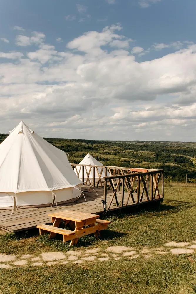 Glampingzelte auf einer Holzterrasse mit Blick ins Tal