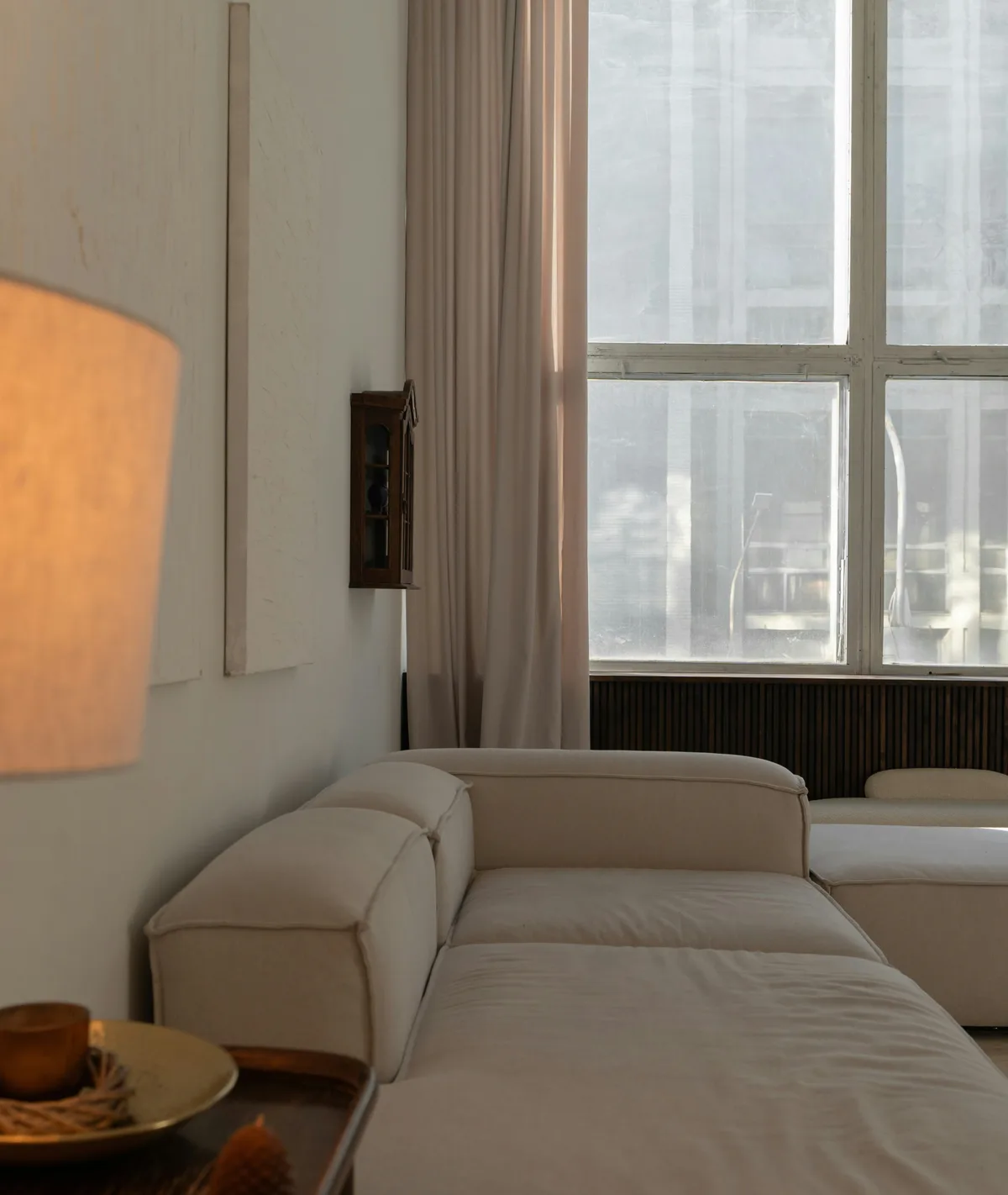 Bright living room with a lamp by a window looking out on the forest